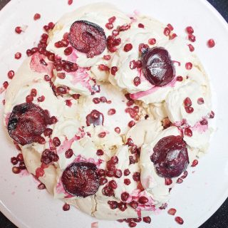 meringue wreath with mulled plums and pomegranates