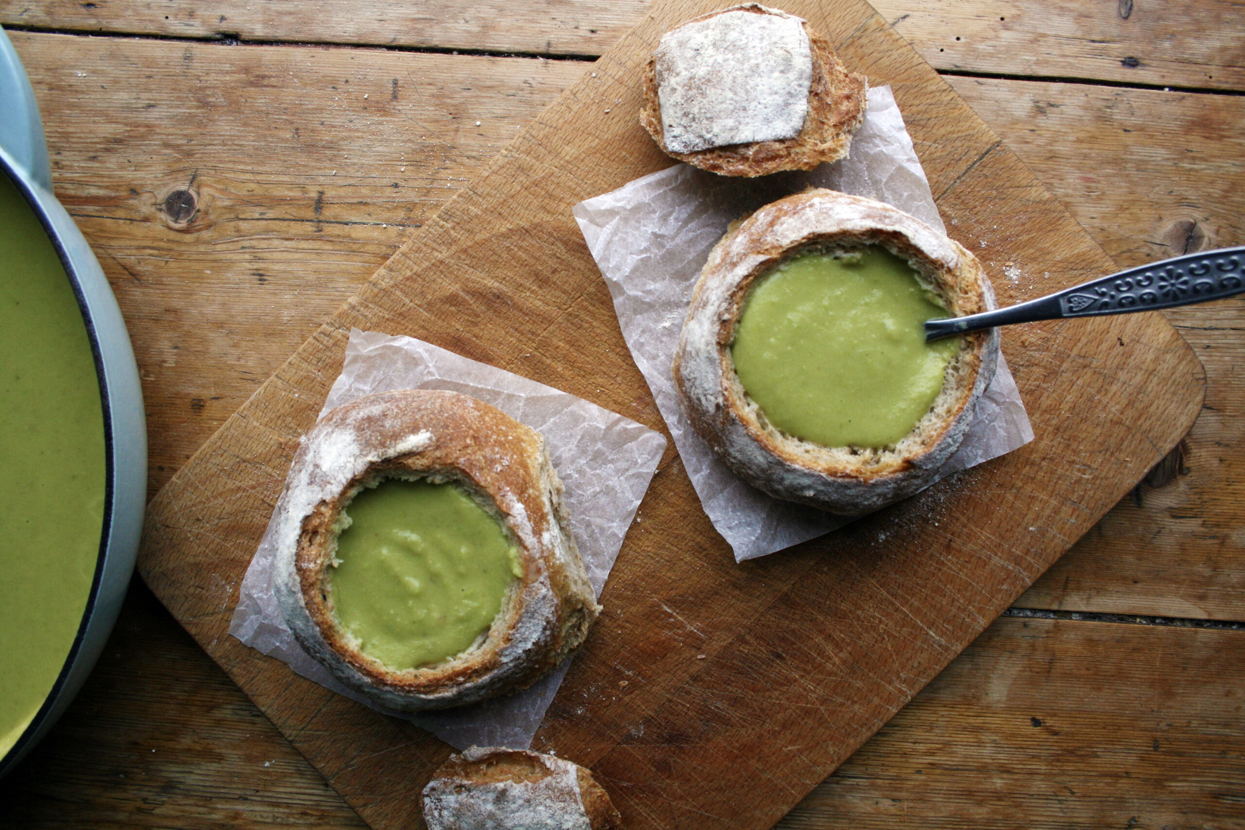 Crusty bread served alongside a bowl of warm pea and ham soup