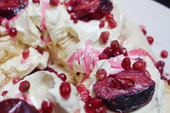 meringue wreath with mulled plums and pomegranates 